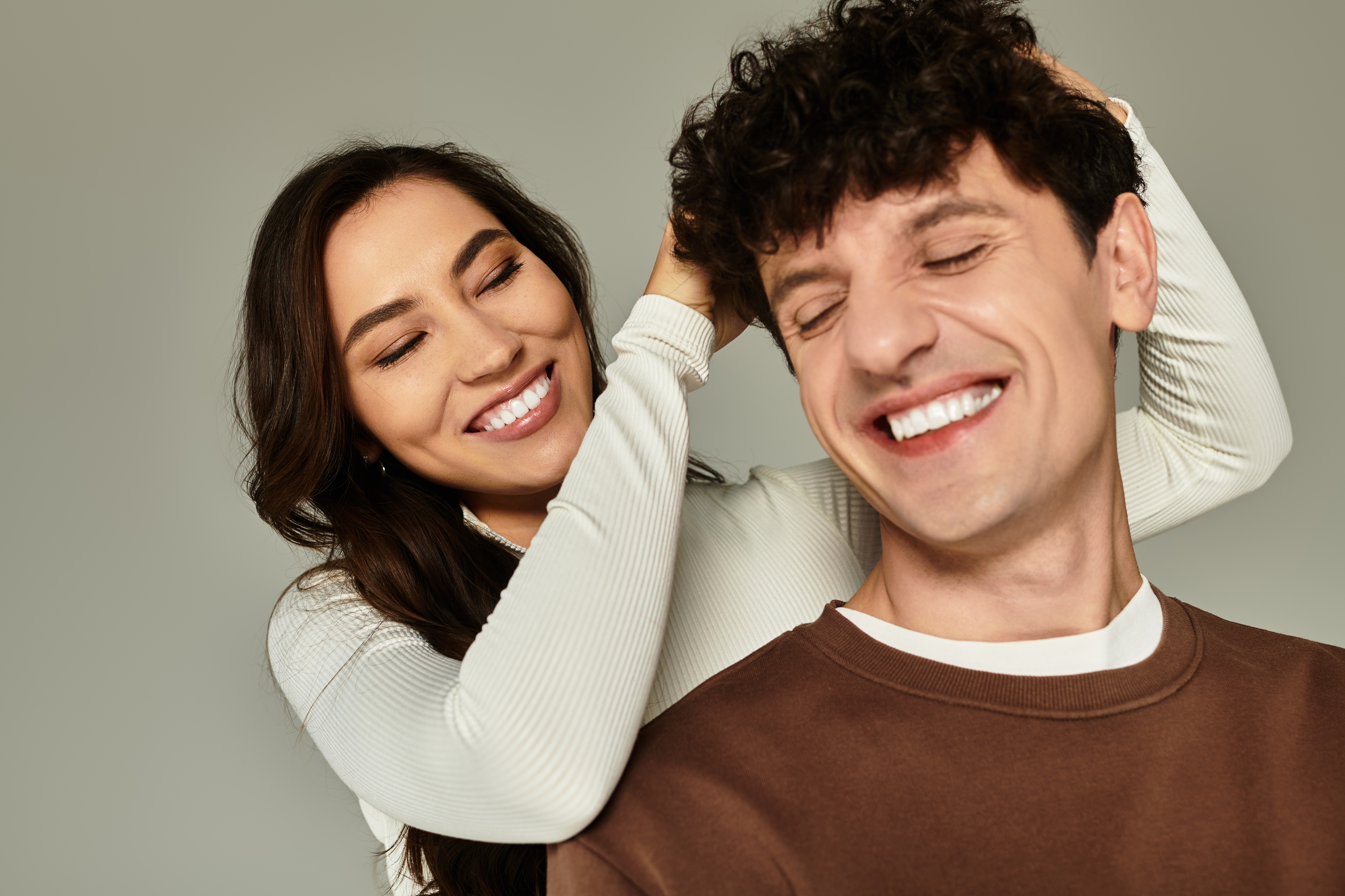 Two stylish young people share joyful moments in a modern studio, radiating happiness.